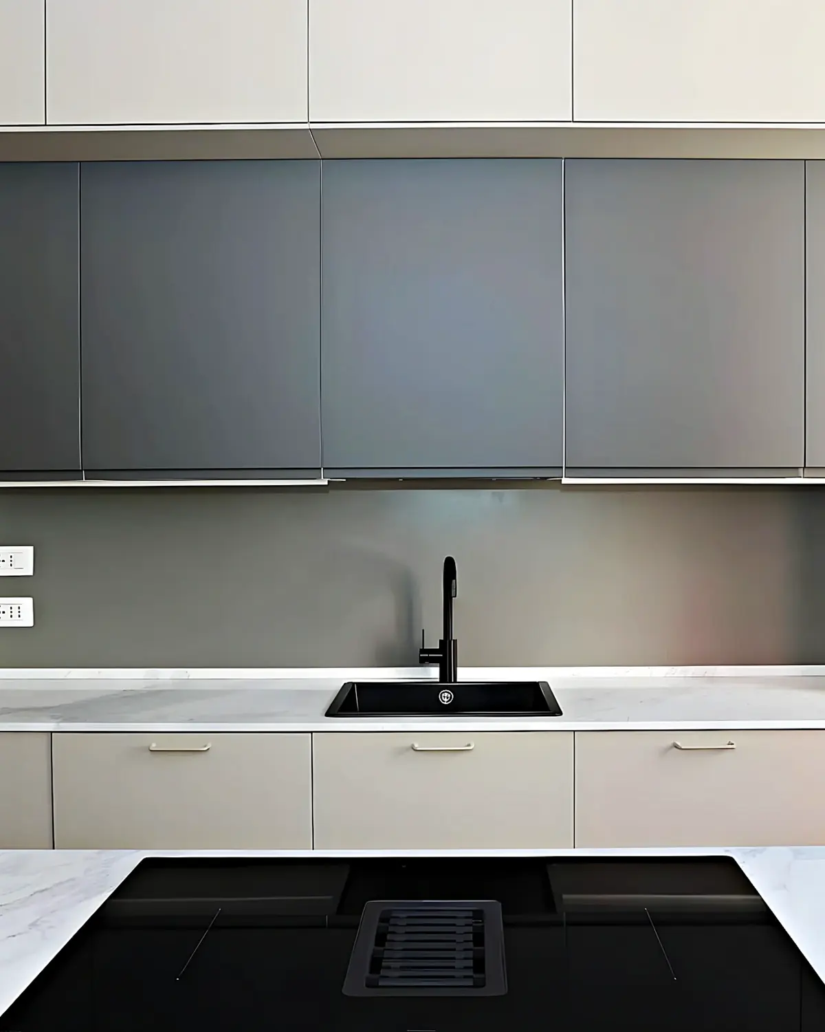 Frente de cocina entregado, con muebles altos en gris, encimera de mármol y fregadero negro
